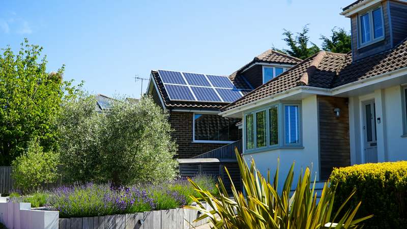 Residential rooftop with modern solar panels under a clear blue sky